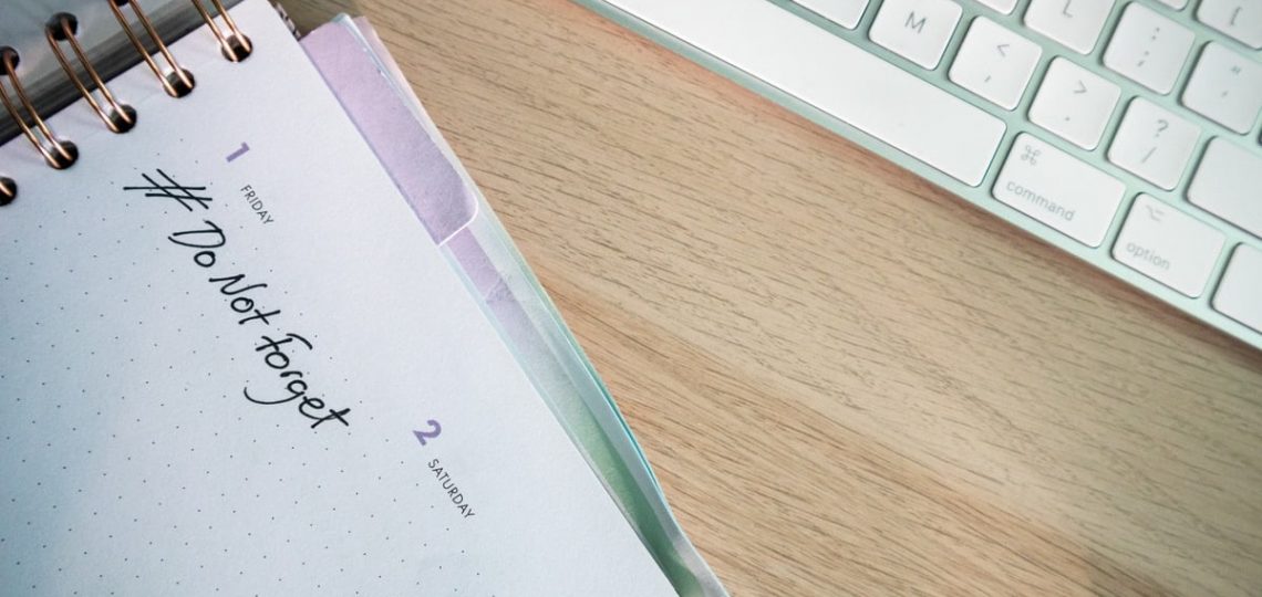 A close-up shot of a planner and keyboard on a desk, showcasing organization.