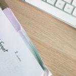 A close-up shot of a planner and keyboard on a desk, showcasing organization.