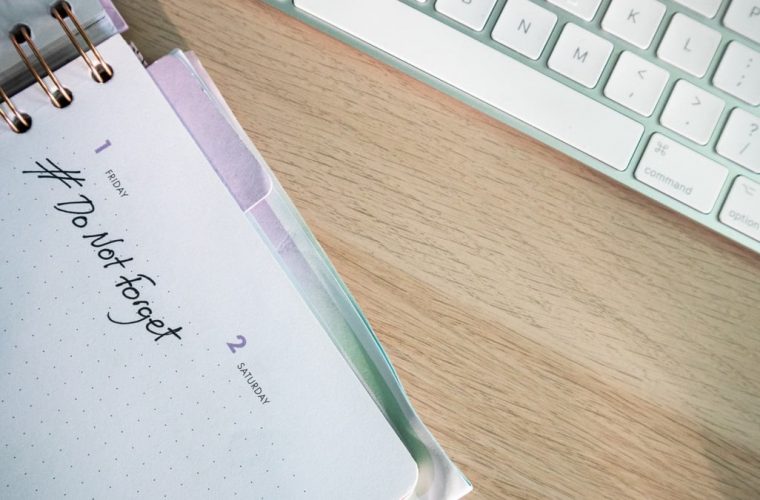 A close-up shot of a planner and keyboard on a desk, showcasing organization.